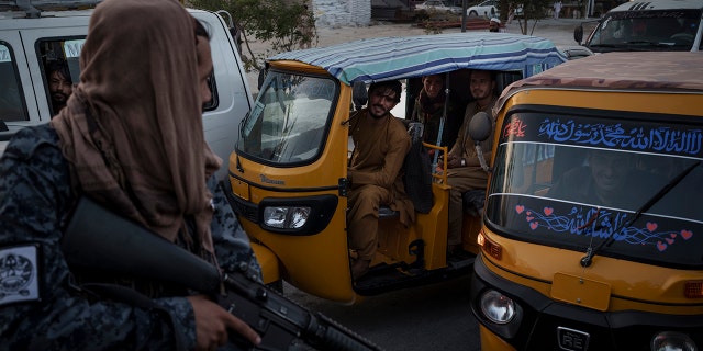 Afghan drivers and passengers stuck in a traffic jam look at Taliban fighters riding in the back of a vehicle in Kabul, Afghanistan, Monday, Sept. 20, 2021. (AP Photo/Felipe Dana)