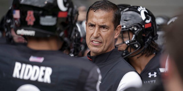 FILE - Cincinnati head coach Luke Fickell speaks with quarterback Desmond Ridder (9) prior to an NCAA college football game against Miami (Ohio) in Cincinnati, in this Saturday, Sept. 4, 2021, file photo.