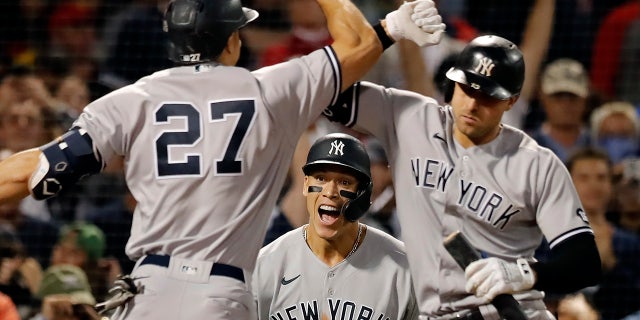 Giancarlo Stanton (27), de los Yankees de Nueva York, celebra su jonrón de dos carreras con Joey Gallo, a la derecha, que también impulsó a Aaron Judge, al centro, durante la octava entrada de un juego de béisbol, el domingo 26 de septiembre de 2021, en Boston. . 
