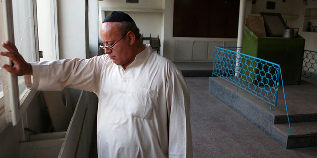 LÊER: Zebulon Simentov, the last known Jew living in Afghanistan, closes the window to the synagogue he cares for in his Kabul home.