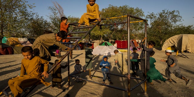 Afghan displaced children play at an internally displaced persons camp in Kabul, Afghanistan, on Monday.