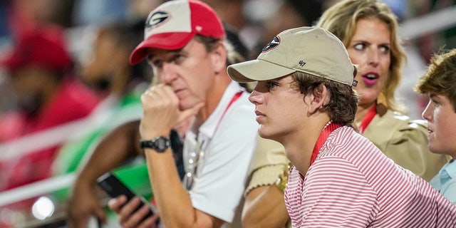 Sep 18, 2021; Athens, Georgia, USA; High school player Arch Manning looks on with his parents during a game between the South Carolina Gamecocks against the Georgia Bulldogs at Sanford Stadium. 