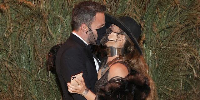 Ben Affleck and Jennifer Lopez are seen kissing through their masks during the Met Gala.