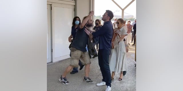 Ben Affleck holds back a fan who tried to get a selfie with his girlfriend, Jennifer Lopez.