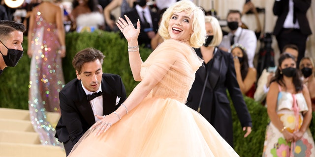 To the party, Eilish wore a custom peach-colored Oscar de la Renta dress with a fitted waist and a long, flowing train.