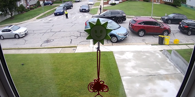 Security camera footage capturing the interaction between the crossing guard and the blue Tesla.