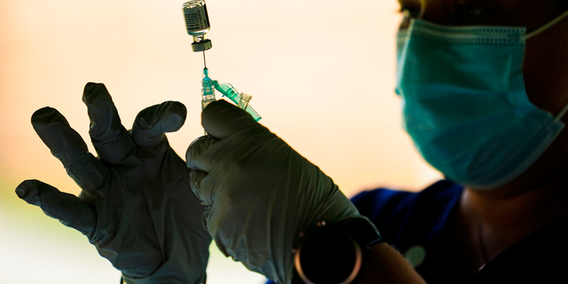 FILE - In this Sept. 14, 2021, file photo, a syringe is prepared with the Pfizer COVID-19 vaccine at a clinic at the Reading Area Community College in Reading, Pa. 