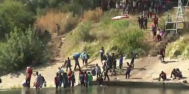 Migrants cross the Rio Grande river