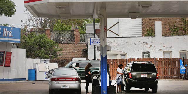 芝加哥, IL - 可能 22: Customers purchase gasoline at a Marathon gas station on May 22, 2014 在芝加哥, 伊利诺伊州. Marathon Petroleum Corp. has agreed to purchase Hess gasoline stations for $ 2.6 十亿. The acquisition will expand Marathon Petroleums retail presence from nine to 23 状态. (Photo by Scott Olson/Getty Images)