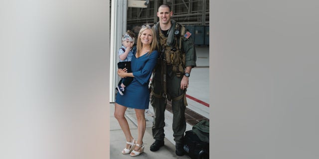 Naval Air Crewman (Helicopter) 2nd Class James P. Buriak, 31, from Salem, Virginia, with wife Megan, and son Caulder.
