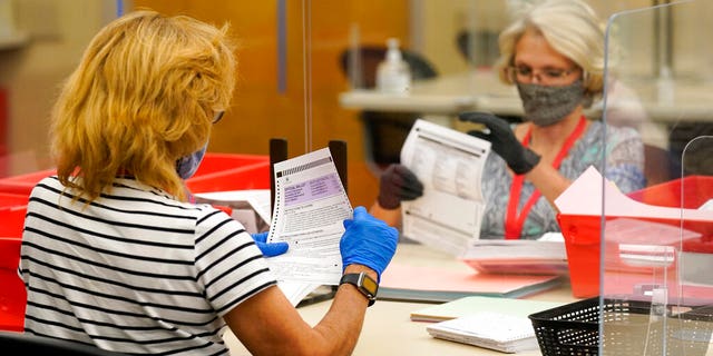 Election workers inspect ballots for damage that have been received for the Sept. 14 recall election at the Sacramento County Registrar of Voters office in Sacramento, Calif., Monday, Aug. 30, 2021. (AP Photo/Rich Pedroncelli)