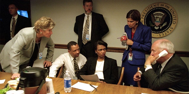 U.S. Vice President Dick Cheney (R) speaks to President George W. Bush by phone inside the operations center at the White House with staff, 9/11/01, the day of the terror attacks in New York and Washington. 