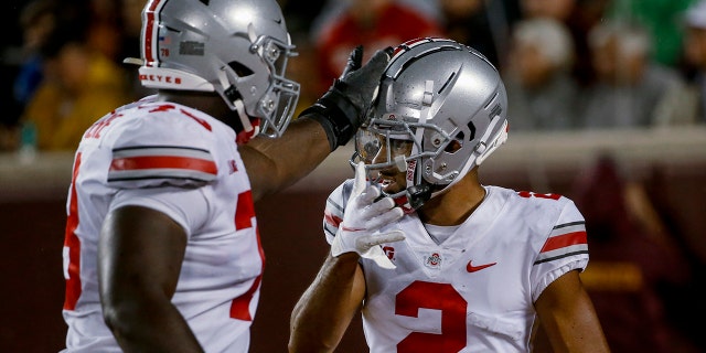 Ohio State wide receiver Chris Olave (2) celebrates his touchdown catch against Minnesota with tackle Nicholas Petit-Frere (78) during the third quarter of an NCAA college football game Thursday, Sept. 2, 2021, in Minneapolis. Ohio State won 45-31.