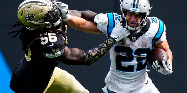 Carolina Panthers running back Christian McCaffrey pushes away from New Orleans Saints outside linebacker Demario Davis during the second half of an NFL football game Sunday, Sept. 19, 2021, in Charlotte, N.C. 