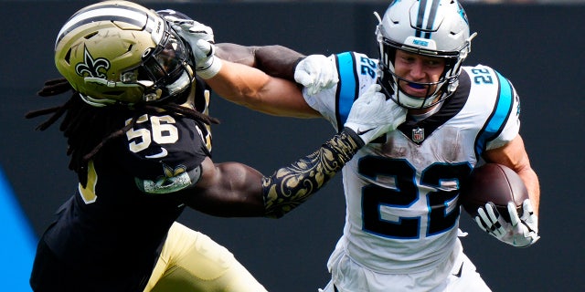 Carolina Panthers running back Christian McCaffrey pushes away from New Orleans Saints outside linebacker Demario Davis during the second half of an NFL football game Sunday, Sept. 19, 2021, in Charlotte, N.C.