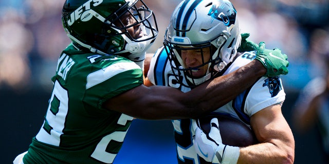 Carolina Panthers running back Christian McCaffrey is tackled by New York Jets free safety Lamarcus Joyner during the first half of an NFL football game Sunday, Sept. 12, 2021, in Charlotte, N.C.