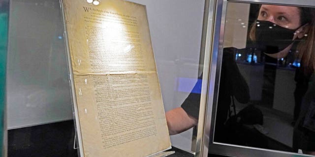 Ella Hall, a specialist in Books and Manuscripts, at Sotheby's, in New York, places a 1787 printed copy of the U.S. Constitution in its display case. It's the only copy that remains in private hands and has an estimate of $15 million-$20 million. (AP Photo/Richard Drew)