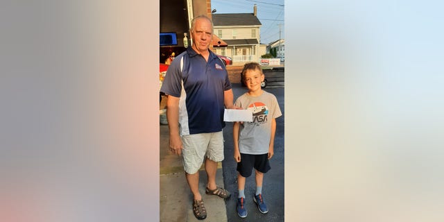 Andrew delivered his earnings by hand to the Friendship Fire Company in Danville, Pennsylvania. Andrew is pictured with the fire chief.