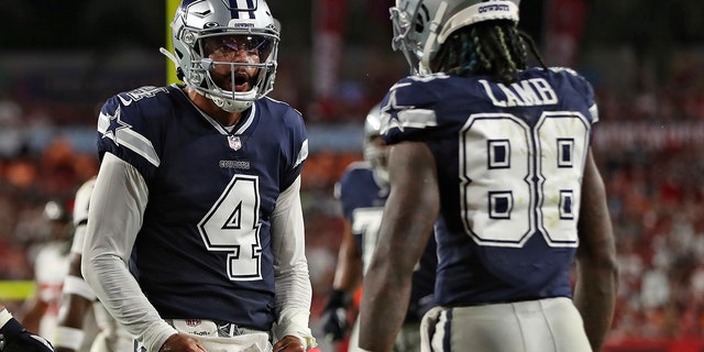 Dallas Cowboys quarterback Dak Prescott (4) celebrates with wide receiver CeeDee Lamb (88) after a touchdown against the Tampa Bay Buccaneers during the first half of an NFL football game Thursday, Sept. 9, 2021, in Tampa, Fla. 