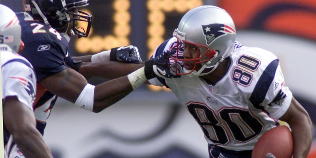 Denver Broncos cornerback Deltha O'Neal (L) grabs the face mask from New England Patriots wide receiver David Patten (80) in the first quarter in Denver on October 28, 2001.