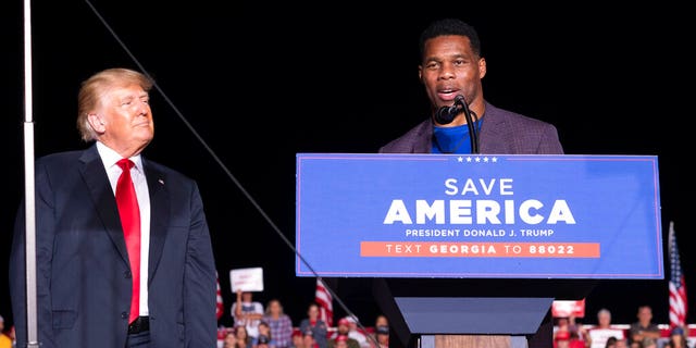 Former President Donald Trump listens as Georgia Senate candidate Herschel Walker speaks during his Save America rally in Perry, Ga., 土曜日, 9月. 25, 2021. 
