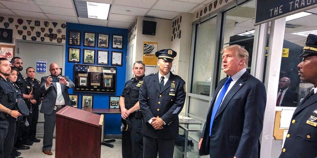 Former President Donald Trump, second from right, commemorated the 20th anniversary of the Sept. 11 attacks by visiting the NYPD's 17th police precinct in New York, on Saturday Sept. 11, 2021. (AP Photo/Jill Colvin)