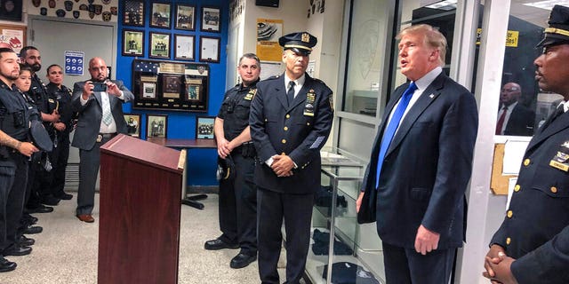 Former President Donald Trump, second from right, commemorated the 20th anniversary of the Sept. 11 attacks by visiting the NYPD's 17th police precinct in New York, on Saturday Sept. 11, 2021. (AP Photo/Jill Colvin)