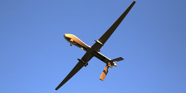 A U.S. Air Force MQ-1B Predator unmanned aerial vehicle (UAV), carrying a Hellfire missile flies over an air base after flying a mission in the Persian Gulf region. 