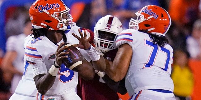 Florida quarterback Emory Jones, left, throws a pass as he get a block from offensive lineman Ethan White (77) during the first half of the team's NCAA college football game against Florida Atlantic, Saturday, Sept. 4, 2021, in Gainesville, Fla.