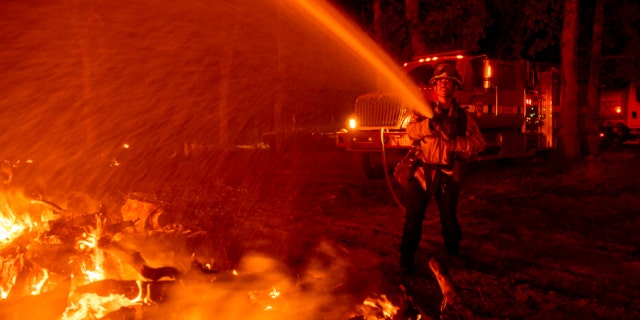Firefighter Ron Burias battles the Fawn Fire as it spreads north of Redding, Calif. in Shasta County, di giovedì, Sett. 23, 2021.
