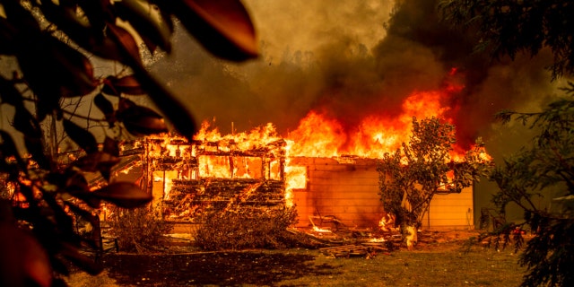 Flames consume a house near Old Oregon Trail as the Fawn Fire burns north of Redding in Shasta County, California, on Thursday, Sept. 23, 2021.