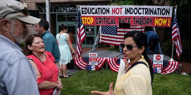People talk before the start of a rally against "critical race theory" (CRT) being taught in schools at the Loudoun County Government center in Leesburg, Virginia on June 12, 2021. (Photo by ANDREW CABALLERO-REYNOLDS / GETTY)