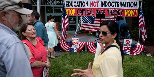 People talk before the start of a rally against "critical race theory" (CRT) being taught in schools at the Loudoun County Government center in Leesburg, Virginia on June 12, 2021. (Photo by ANDREW CABALLERO-REYNOLDS / GETTY)