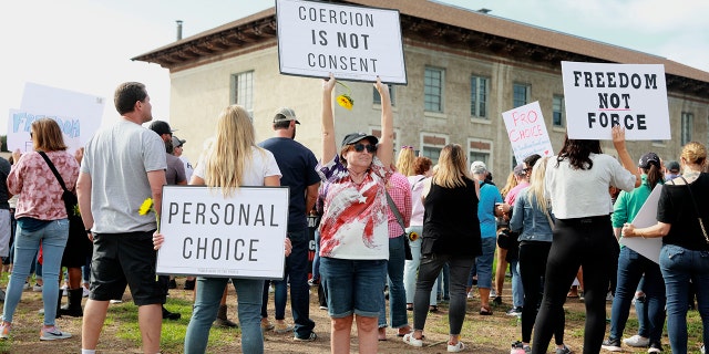 Anti-vaccine protesters stage a demonstration outside the San Diego Unified School District office in San Diego, California, Sept. 28, 2021.