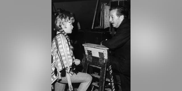American film producer Walt Disney talking to British actress Hayley Mills on the set of his film ‘The Castaways’.