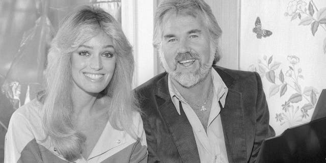 American actress and singer Susan Anton American singer, songwriter, musician, actor, record producer, and entrepreneur Kenny Rogers (1938-2020) pose for a portrait circa 1987 in Los Angeles, California.