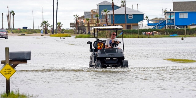 Joe Ward drives down through floodwaters from Hurricane Nicholas Tuesday, Sept. 14, 2021, in Surfside Beach, Texas.