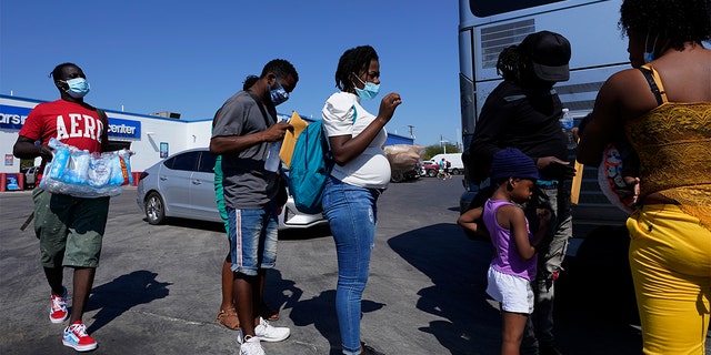 In this Sept. 20, 2021, file photo, migrants, many from Haiti, board a bus after they were processed and released after spending time at a makeshift camp near the International Bridge in Del Rio, Texas. (AP Photo/Eric Gay, File)