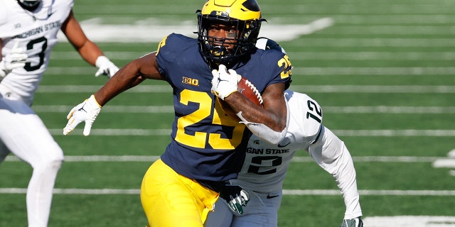 Michigan Wolverines running back Hassan Haskins rushes against the Michigan State Spartans at Michigan Stadium.