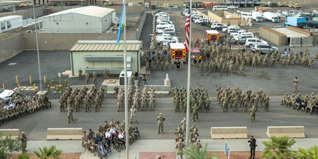 Membre de service avec la Force opérationnelle interarmées - Corne de l'Afrique, se tient en formation lors d'une cérémonie de la Journée des Patriotes au Camp Lemonnier, Djibouti, le 11 septembre 2021, commémorant le 20e anniversaire des attaques terroristes du 11 septembre 2001. La cérémonie commémorative comprenait une formation interarmées, un survol multi-avions, une présentation des couleurs et le jeu de Taps.  Le Camp Lemonnier a organisé plusieurs événements en l'honneur et à la mémoire de ceux qui ont perdu la vie ce jour-là et au cours des deux dernières décennies en combattant la guerre mondiale contre le terrorisme.