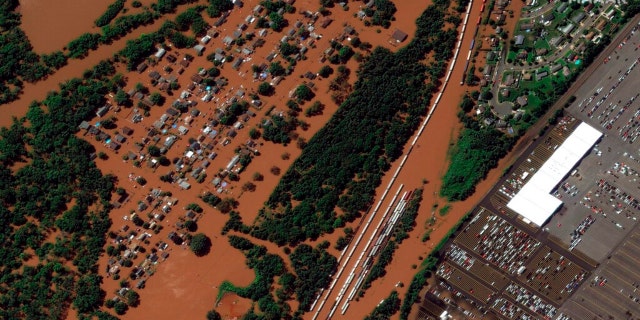 In a satellite image provided by Maxar Technologies, homes are surrounded by floodwaters from the Raritan River in Manville, N.J., Thursday, Sept. 2, 2021, the day after remnants of Hurricane Ida swept through the area.