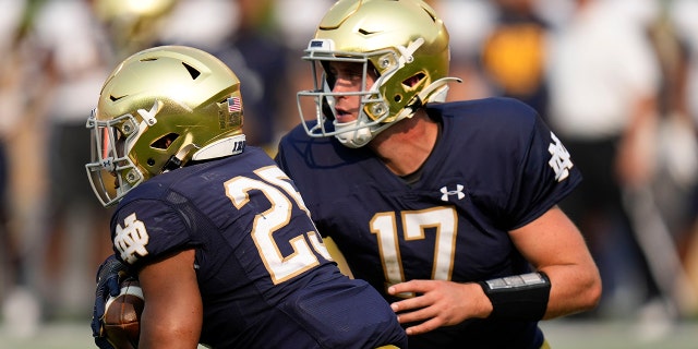 Notre Dame quarterback Jack Coan hands off to running back Chris Tyree against Toledo in South Bend, Indiana, on Sept. 11, 2021.