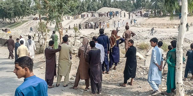 Taliban operatives and people gather at the site of a bomb explosion that targeted a van carrying Taliban fighters in Jalalabad on September 19, 2021, a day after at least two people were killed in a series explosions in the area.