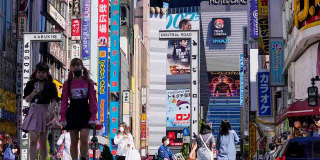 BESTAND - Op deze bestandsfoto van 20 september 2021 lopen mensen die gezichtsmaskers dragen ter bescherming tegen COVID-19 door een oversteekplaats in Shinjuku, een recreatiegebied in Tokio.