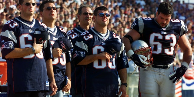 Prior to the Patriots-New York Jets game at Foxborough Stadium, New England Patriots' offensive lineman Joe Andruzzi (far right), and his three New York City firefighter brothers, así como su padre (third from left), participate in a ceremony in memory of the people lost on September 11.