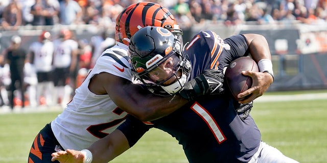 Chicago Bears quarterback Justin Fields (1) carries the ball and is tackled by Cincinnati Bengals cornerback Chidobe Awuzie during the second half of an NFL football game Sunday, Sept. 19, 2021, in Chicago.