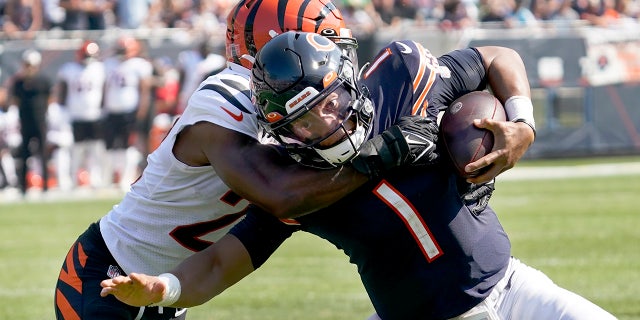 Chicago Bears quarterback Justin Fields (1) carries the ball and is tackled by Cincinnati Bengals cornerback Chidobe Awuzie during the second half of an NFL football game Sunday, Sept. 19, 2021, in Chicago.