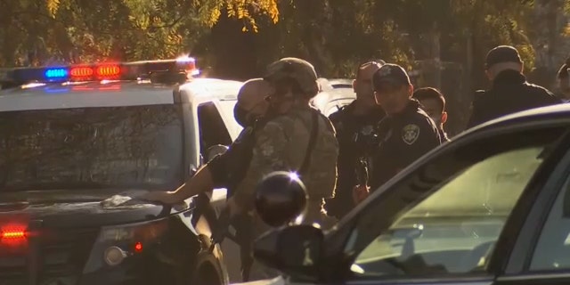 Authorities are seen in Oakland, Calif., on Wednesday. Police said one officer was shot by a suspect who later barricaded themselves in a building. (KTVU)