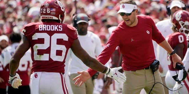 Oklahoma head coach Lincoln Riley, right, greets running back Kennedy Brooks (26) as Brooks returns to the sidelines following a touchdown against Nebraska in the second half of an NCAA college football game, Saturday, Sept. 18, 2021, in Norman, Okla. (AP Photo/Sue Ogrocki)