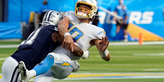 Los Angeles Chargers quarterback Justin Herbert is hit by Dallas Cowboys linebacker Micah Parsons as he throws during the second half of an NFL football game Sunday, Sept. 19, 2021, in Inglewood, Calif.